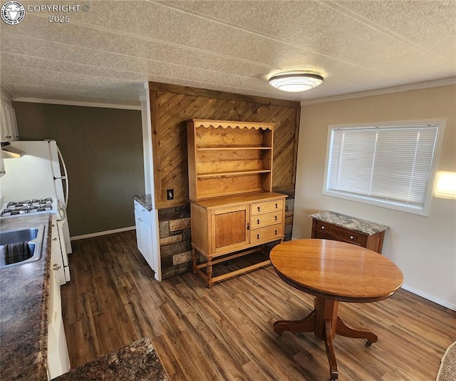 dining area featuring ornamental molding, dark hardwood / wood-style floors, sink, and a textured ceiling