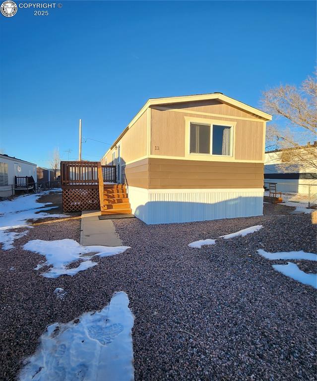 view of snowy exterior with a wooden deck