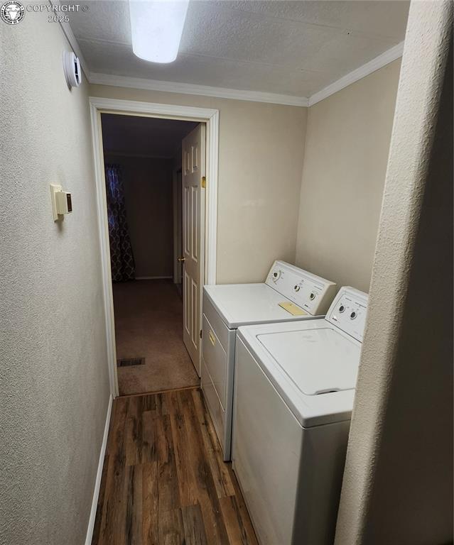 washroom with dark hardwood / wood-style flooring, crown molding, washer and dryer, and a textured ceiling