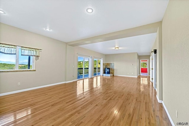 unfurnished living room featuring a tile fireplace and light wood-type flooring