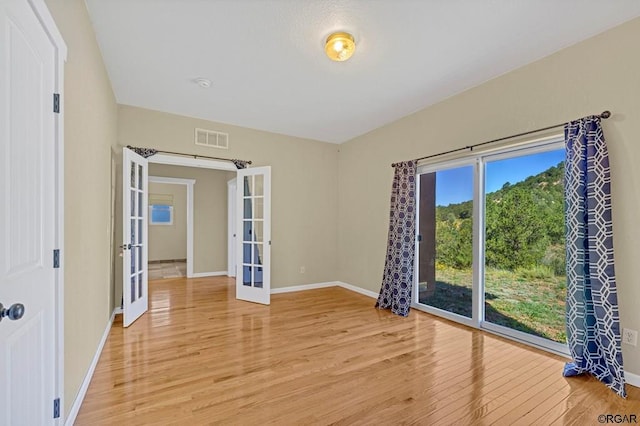 empty room with french doors and light wood-type flooring