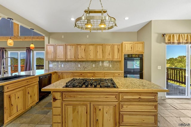 kitchen featuring decorative light fixtures, sink, backsplash, a center island, and black appliances