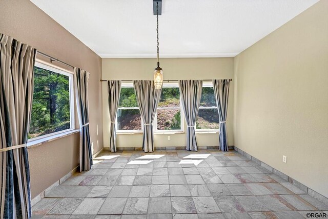 unfurnished dining area featuring plenty of natural light