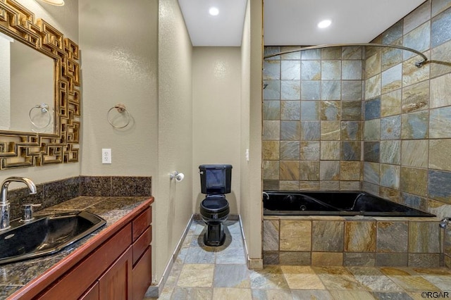 bathroom featuring tiled shower / bath and vanity