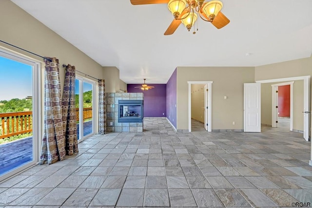 unfurnished living room featuring ceiling fan and a fireplace