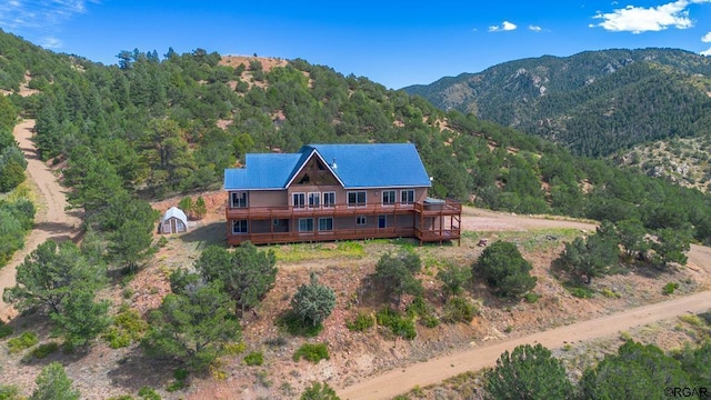 rear view of house featuring a deck with mountain view