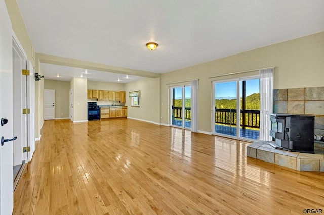 unfurnished living room with light hardwood / wood-style flooring and a wood stove