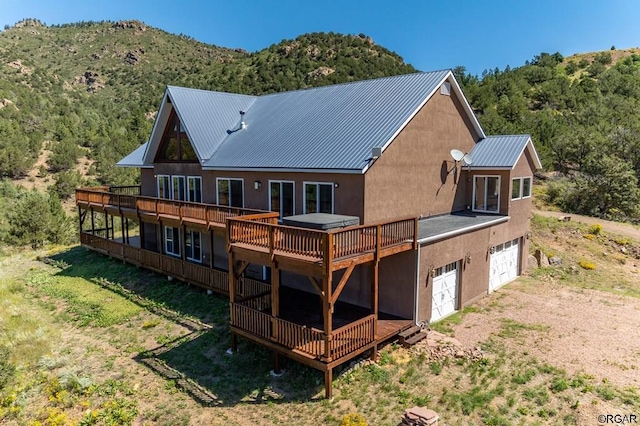 rear view of property with a garage and a deck