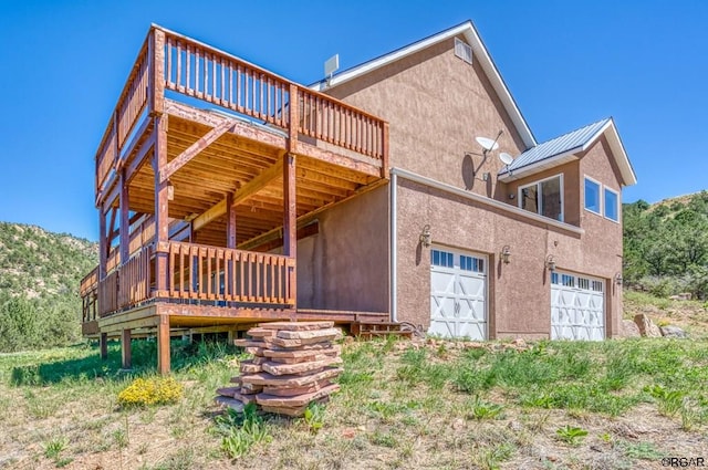 back of house with a wooden deck and a garage