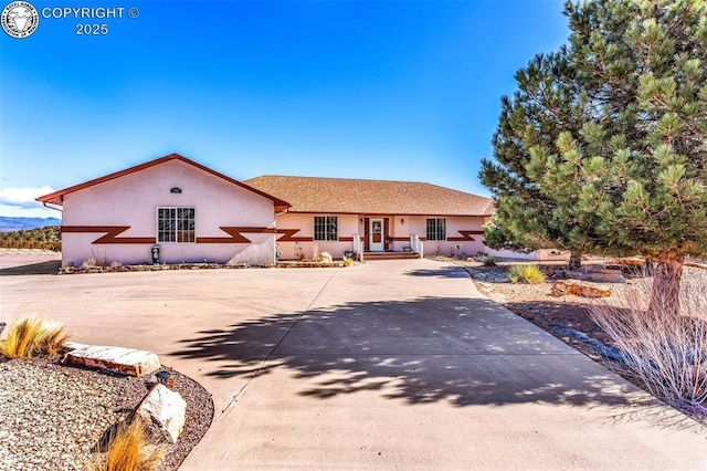 single story home with driveway and stucco siding