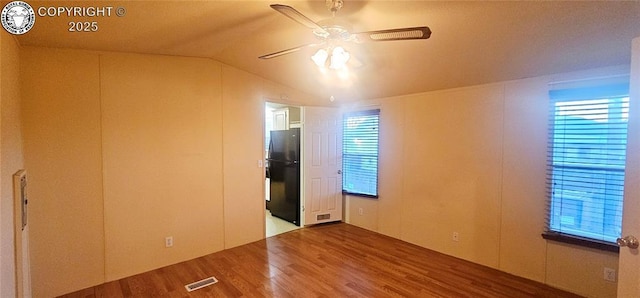 empty room with hardwood / wood-style flooring, lofted ceiling, plenty of natural light, and ceiling fan