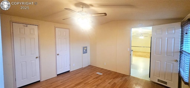 unfurnished bedroom with lofted ceiling, hardwood / wood-style floors, and ceiling fan