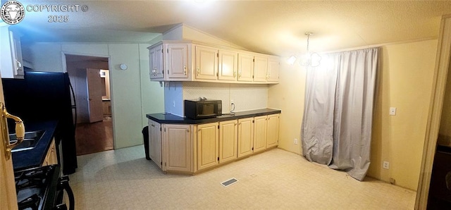 kitchen with a notable chandelier, decorative light fixtures, black appliances, and cream cabinetry