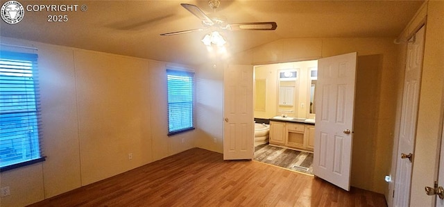 unfurnished bedroom with ensuite bathroom, lofted ceiling, ceiling fan, and light hardwood / wood-style floors