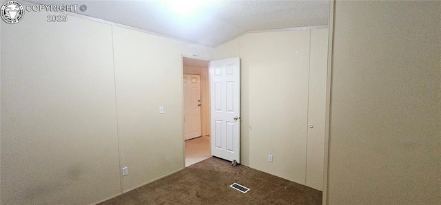 unfurnished bedroom featuring dark colored carpet and vaulted ceiling