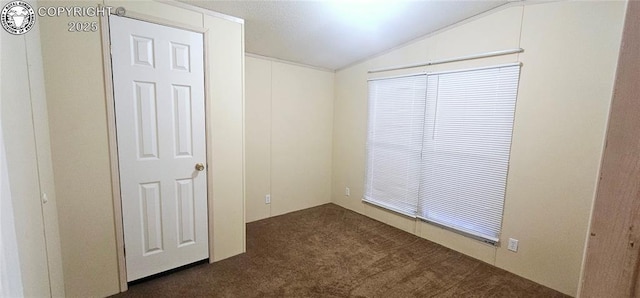 carpeted spare room with vaulted ceiling