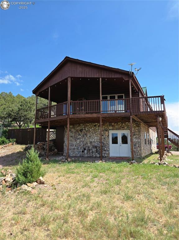 612 Lowry Ln, Canon City, CO 81212 - back of property featuring a wooden deck, stairs, and stone siding
