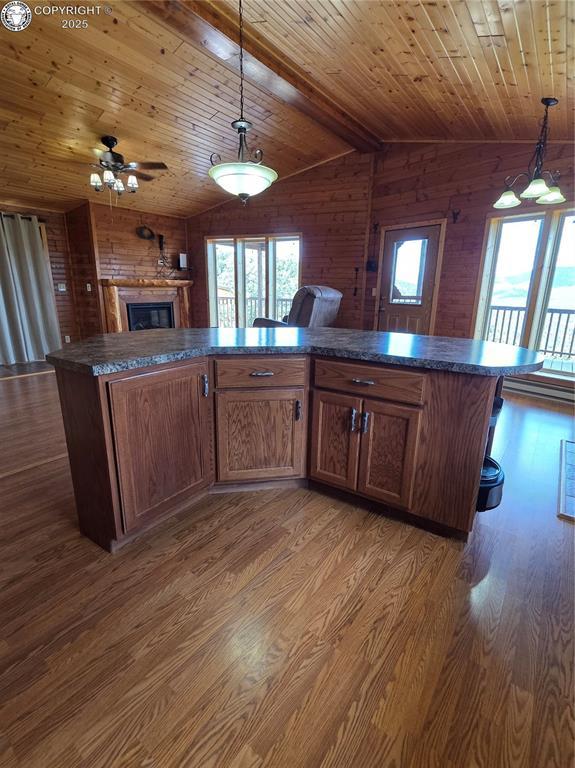 612 Lowry Ln, Canon City, CO 81212 - kitchen with wood walls, dark countertops, wooden ceiling, dark wood-style flooring, and open floor plan