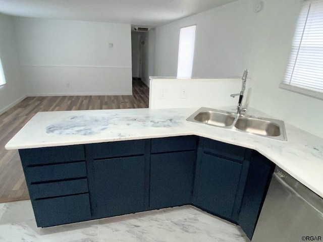 kitchen featuring blue cabinets, dishwasher, sink, kitchen peninsula, and light hardwood / wood-style flooring