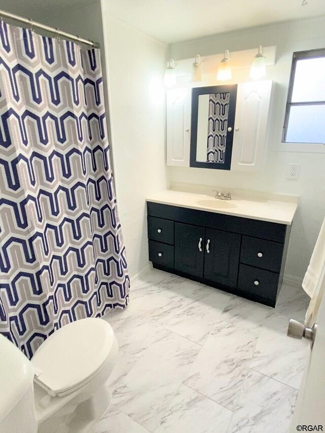 bathroom with vanity, curtained shower, and toilet