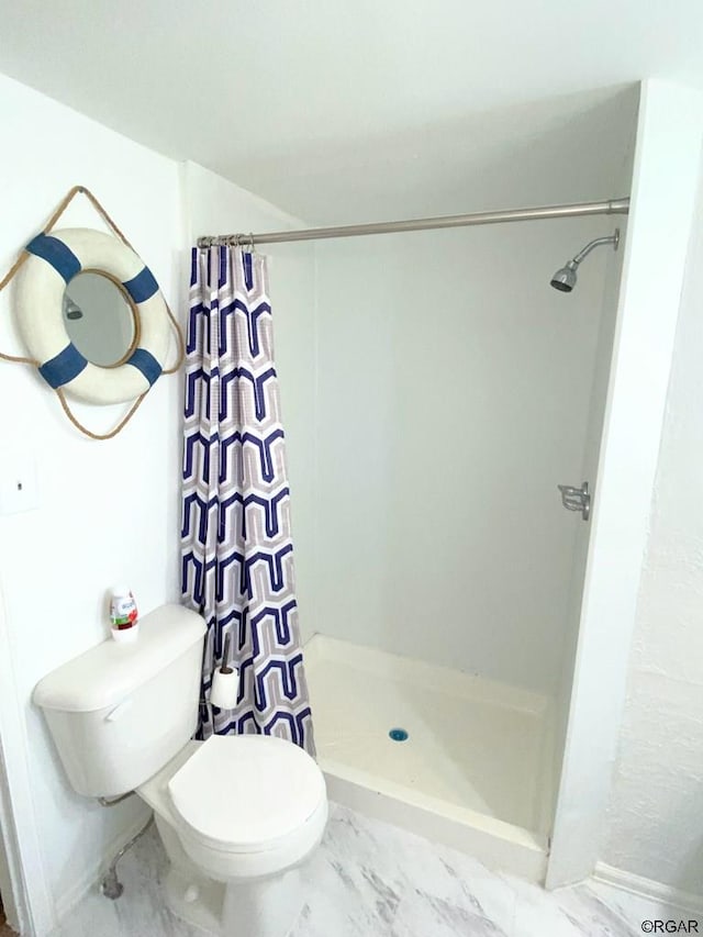 bathroom featuring a shower with curtain and toilet