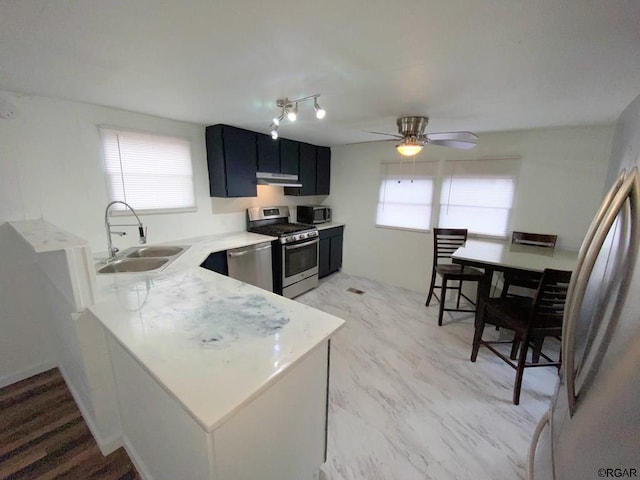 kitchen with ceiling fan, appliances with stainless steel finishes, kitchen peninsula, and sink