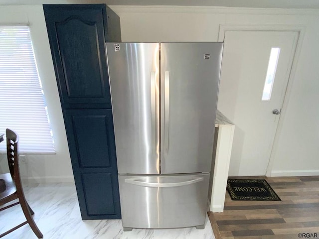 kitchen featuring ornamental molding, stainless steel refrigerator, and blue cabinetry