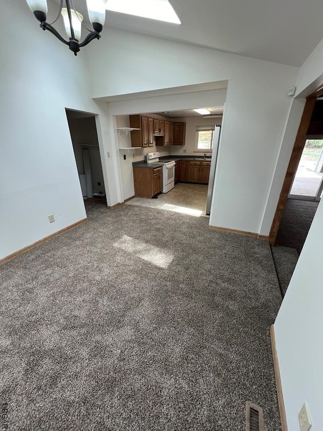 unfurnished living room featuring lofted ceiling, light carpet, and a notable chandelier