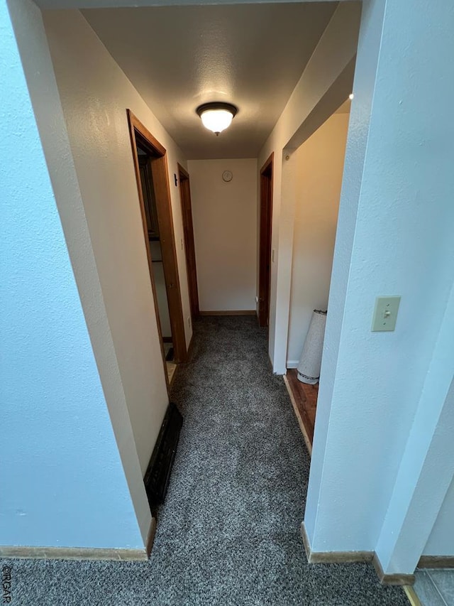 hallway featuring dark carpet