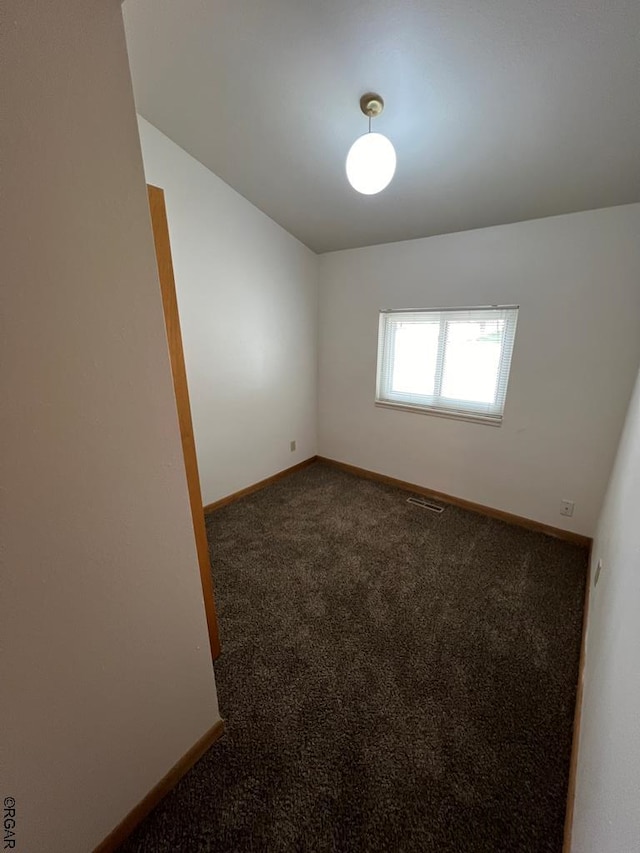 empty room featuring dark colored carpet