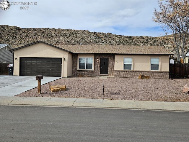 single story home with a garage, brick siding, fence, concrete driveway, and stucco siding