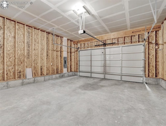 garage with a garage door opener and electric panel