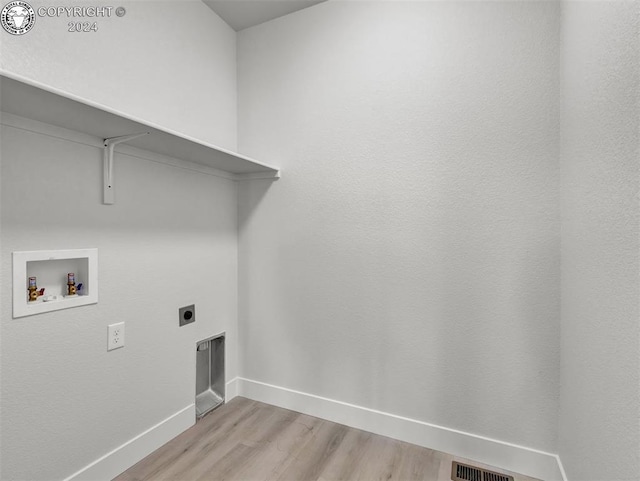 laundry area featuring hookup for an electric dryer, light hardwood / wood-style floors, and hookup for a washing machine