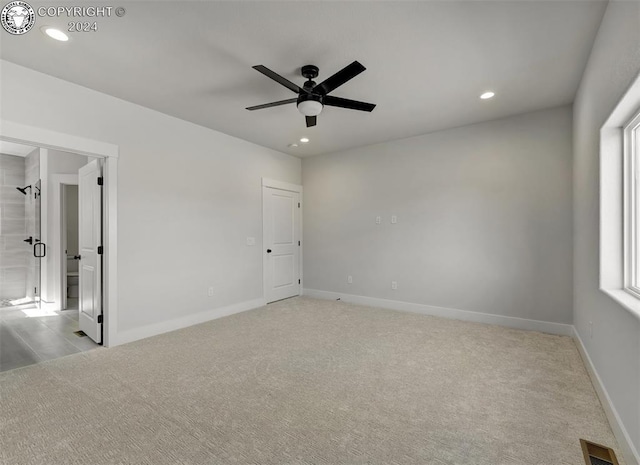 carpeted empty room featuring a healthy amount of sunlight and ceiling fan