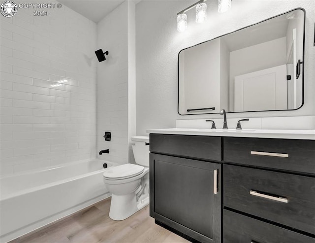 full bathroom featuring vanity, hardwood / wood-style flooring, toilet, and tiled shower / bath