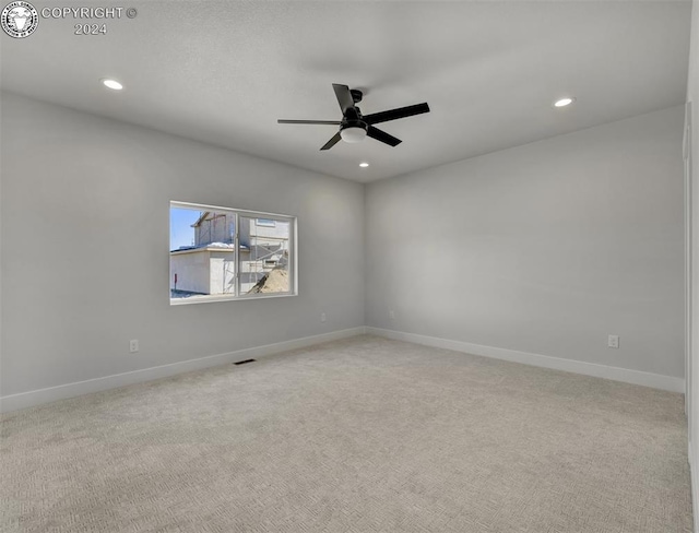 unfurnished room featuring light colored carpet and ceiling fan