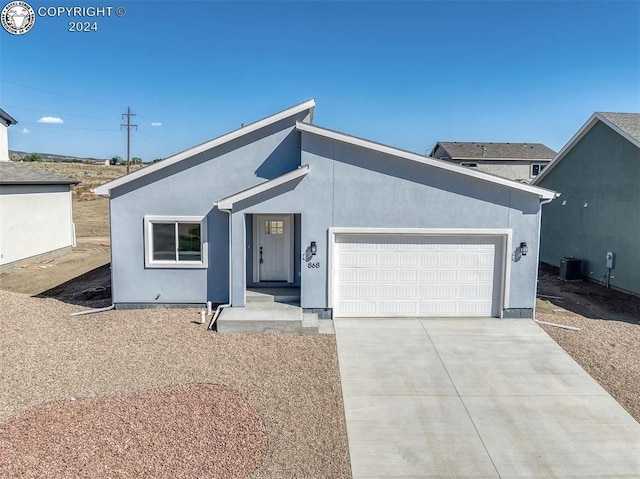 view of front of home with central AC unit and a garage