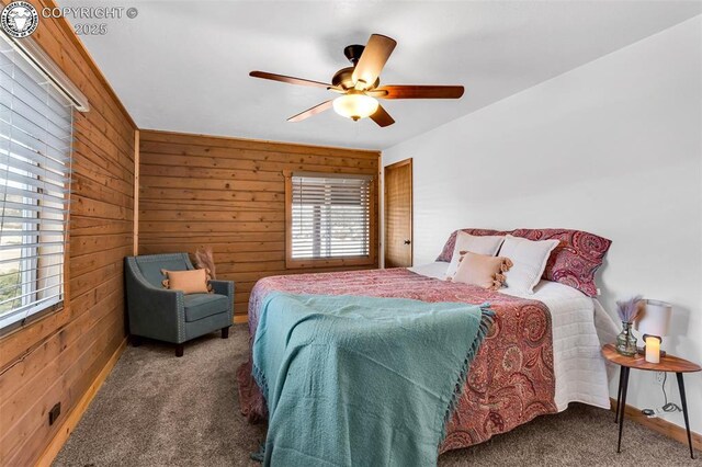 bedroom featuring dark colored carpet, ceiling fan, and wooden walls