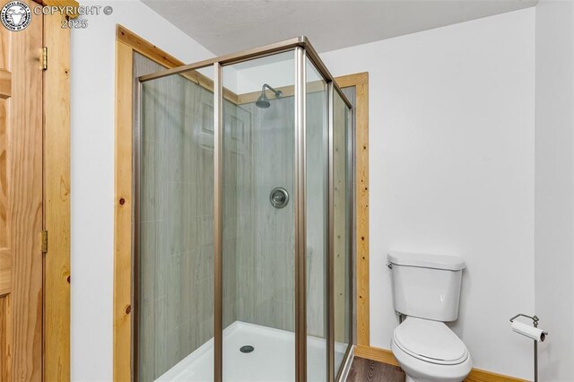 bathroom featuring an enclosed shower and toilet