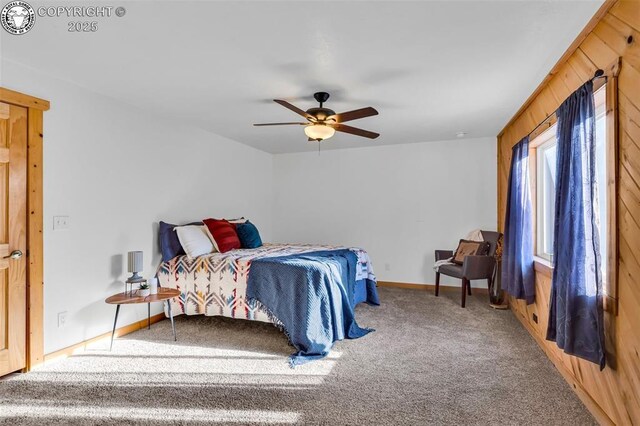 bedroom with carpet, ceiling fan, and wood walls