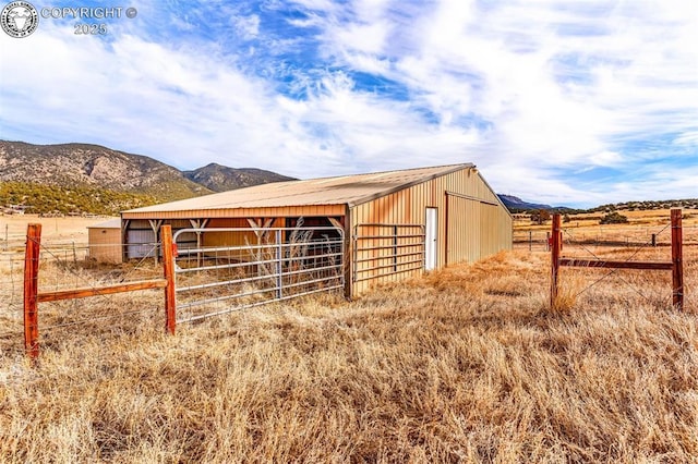 view of stable featuring a rural view and a mountain view