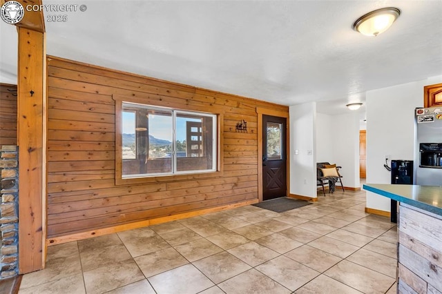 tiled entryway featuring wood walls