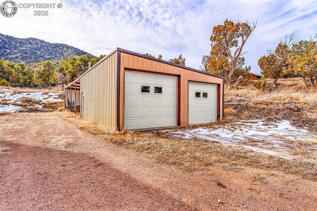 snow covered garage featuring a mountain view