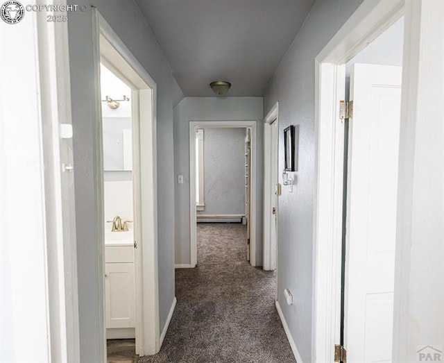 2723 3rd Ave, Pueblo, CO 81003 - hallway with a sink, dark colored carpet, baseboards, and a baseboard heating unit