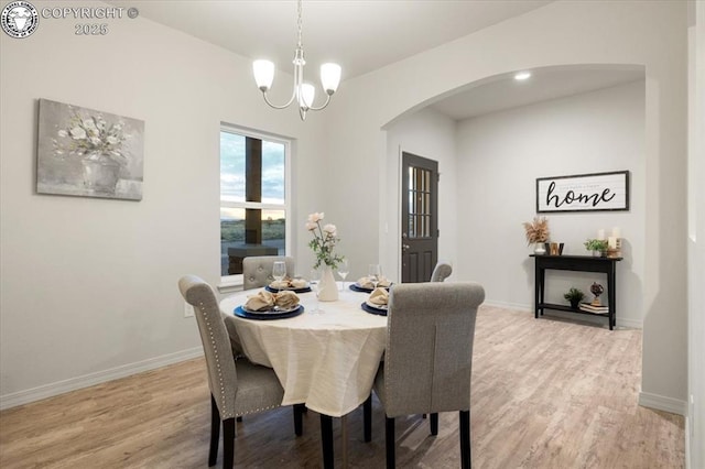 dining space with an inviting chandelier and light hardwood / wood-style flooring