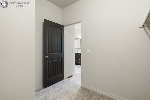 hallway featuring light colored carpet