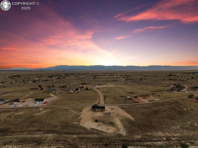 aerial view at dusk featuring a mountain view