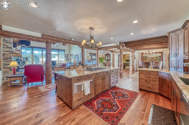 kitchen featuring ornate columns, pendant lighting, a notable chandelier, and light hardwood / wood-style flooring