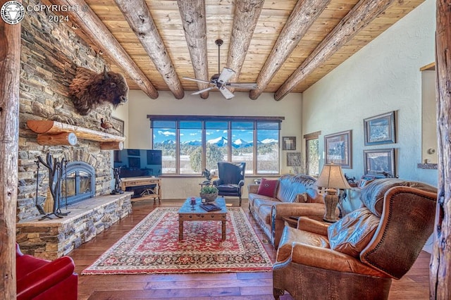 living room featuring a stone fireplace, wood ceiling, ceiling fan, beam ceiling, and hardwood / wood-style floors