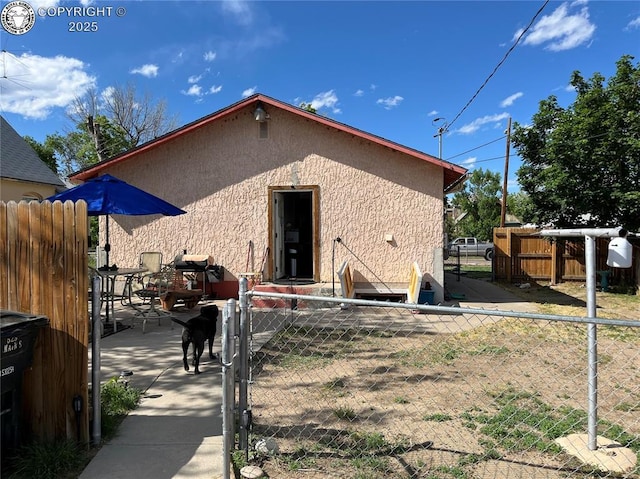 529 W Main St, Florence, CO 81226 - rear view of house featuring stucco siding and a gate